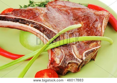 cibo di carne: manzo alla griglia di ricambio rib sul piatto verde con timo pepe e pomodoro isolato sopra ba bianco