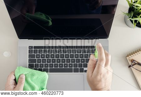 Computer Cleaning Concept. Top View Of A Male Human Hands Cleaning A Laptop Screen With Cleaning Spr