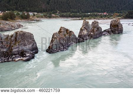 A Fast-flowing Wide And Full-flowing Mountain River. Large Rocks Stick Out Of The Water. Big Mountai