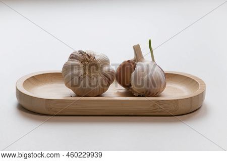 Garlic In A Wooden Bowl On A White Background