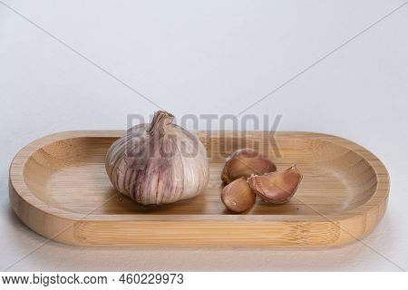 Garlic In A Wooden Bowl On A White Background