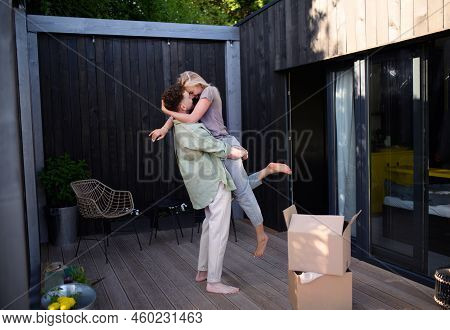 Cheerful Young Couple Moving In Their New Tiny House In Woods. Conception Of Moving And Sustainable 