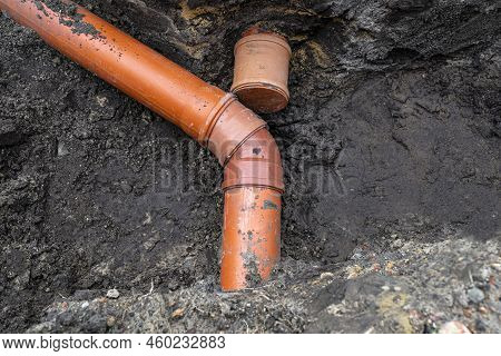 An Orange Plastic Pipe From A Septic Tank With A Diameter Of 160 Mm Lying In A Ditch.