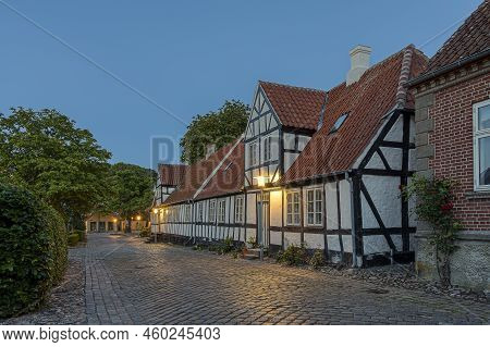 Street Lamps Illuminate An Old Black And White Half-timbered House On A Cobbled Street In The Pictur