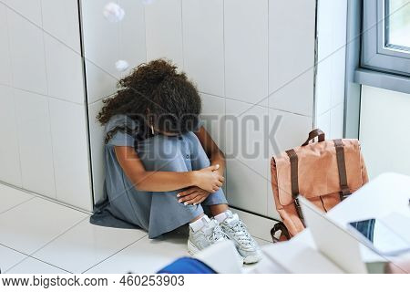 High Angle View Of Young Black Girl Bullied In School And Sitting On Floor With Headphones