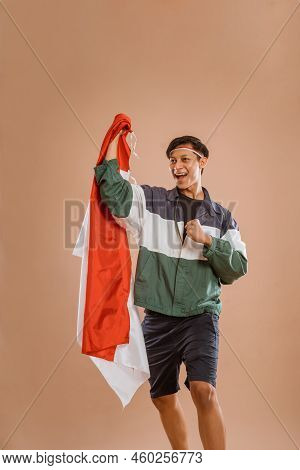 Male Athelete From Indonesia Holding Indonesian Flag Proudly