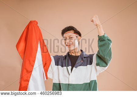 Male Athelete From Indonesia Holding Indonesian Flag Proudly