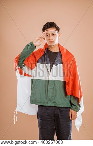 Male Athelete From Indonesia Giving Salute To Indonesian Flag Proudly