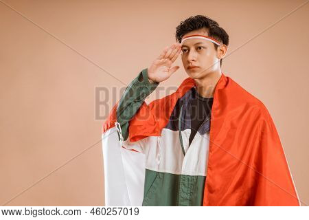 Male Athelete From Indonesia Giving Salute To Indonesian Flag Proudly