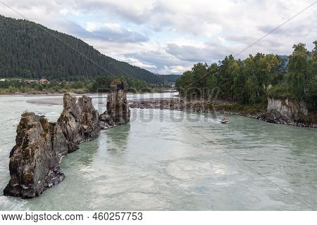 A Fast-flowing Wide And Full-flowing Mountain River. Large Rocks Stick Out Of The Water. Big Mountai