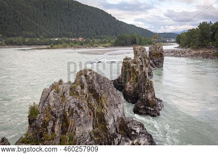 A Fast-flowing Wide And Full-flowing Mountain River. Large Rocks Stick Out Of The Water. Big Mountai