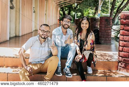 Portrait Of Happy Teenagers Sitting Outside Giving Thumbs Up, Close Up Of Happy Sitting Students Giv