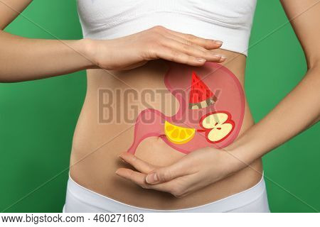 Woman With Image Of Stomach Full Of Food Drawn On Her Belly Against Green Background, Closeup. Healt