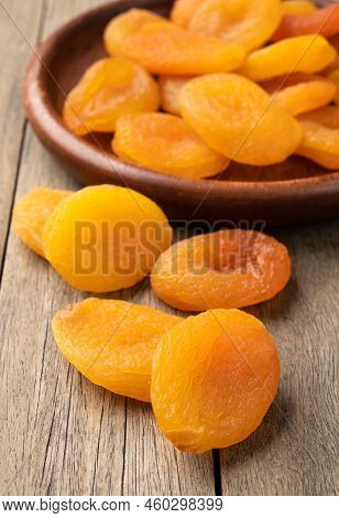 Dried Apricots In A Plate Over Wooden Table.