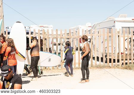 Aveiro, Portugal - August 19, 2022: People Equip Themselves With Wetsuits And Pick Up Surfboards At 