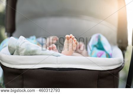 Little Cute Feet Of A Newborn Baby In A Stroller, The Baby Sleeps In The Stroller While Walking, Lea