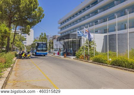 View Of Arriving Tourists Coming In To Hotel. Transfer Busses And Hotel Building On Blue Sky Backgro