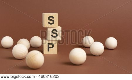 Pyramid Of Wooden Cubes With The Abbreviation Ssp, Wooden Balls On A Brown Background