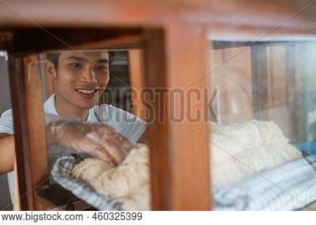 Young Seller Man Taking Noodles While Selling