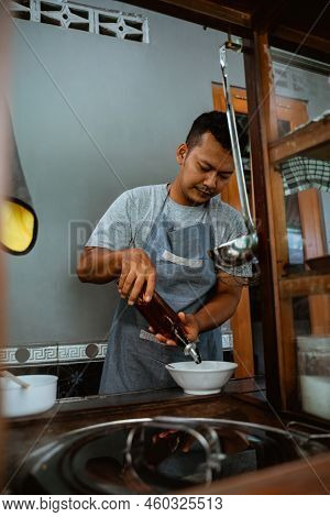 Man Seller Pouring Vegetable Oil From A Bottle To Bowl
