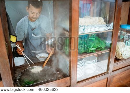 Man Seller Pick Up The Cooked Noodles With Chopsticks
