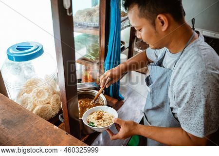 Man Seller Giving Chicken To Noodles When Preparing Dishes