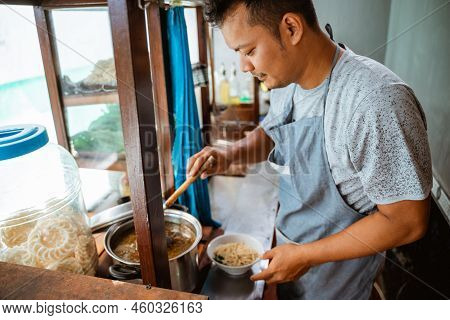 Man Seller Take The Chicken Seasoning Topping In The Pot