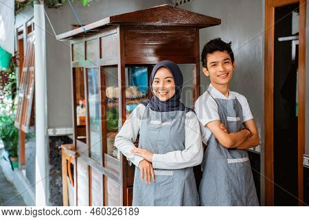 A Couple Of Sellers With Their Hands Crossed Smiling