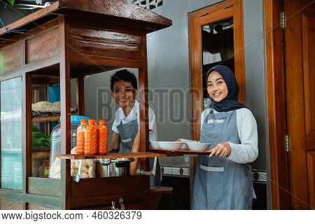 Smiling Two Sellers Preparing Chicken Noodles Dish With Bowls