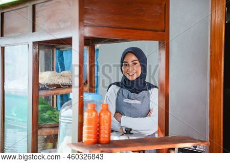 Female Seller In Hijab Wearing Apron Standing With Crossed Hands