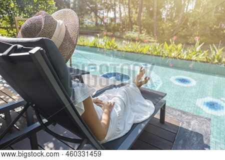 Portrait Beautiful Traveler Asian Woman In White Dress And Straw Hat Relaxing On Chair Beach By The