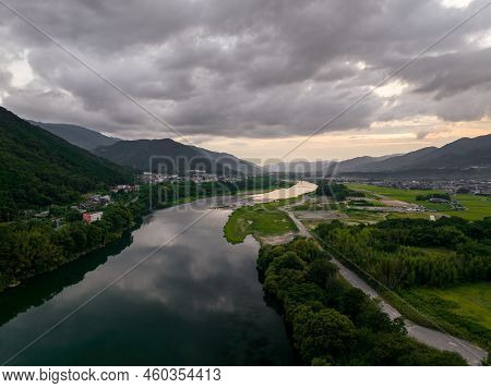 River Flows Through Rural Valley And Small Towns After Sunset