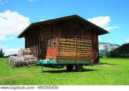 Wooden Shed On A Meadow Under A Blue Sky