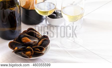 Steamed Mussels With Glass Of Wine On The Table In Restaurant. Typical Mediterranean's Dish Backgrou