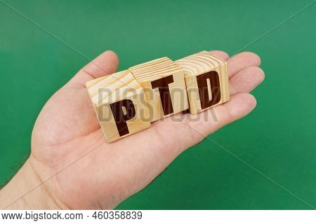 Business Concept. On A Green Background, In The Hands Of A Person, Cubes With The Inscription - Ptd