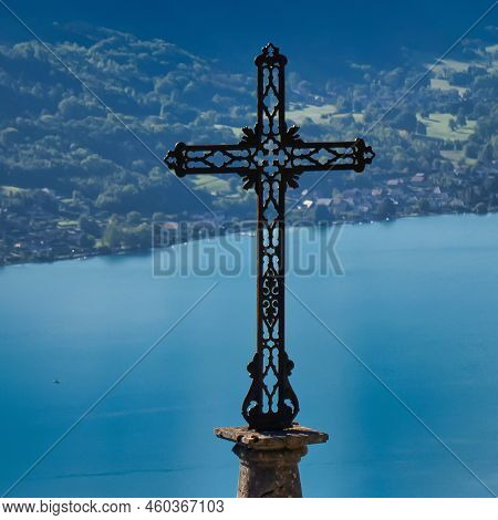 Talloires, France - September 08 2020 : An Enormous Iron Cross Of The Saint Germain Church Overlooks