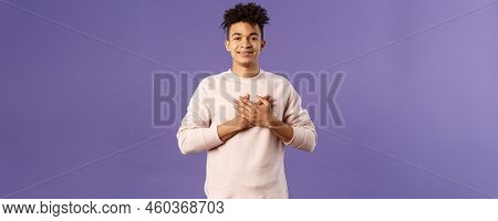 Portrait Of Romantic Handsome Hispanic Man With Dreads, Hold Hands Pressed To Heart And Smiling Plea