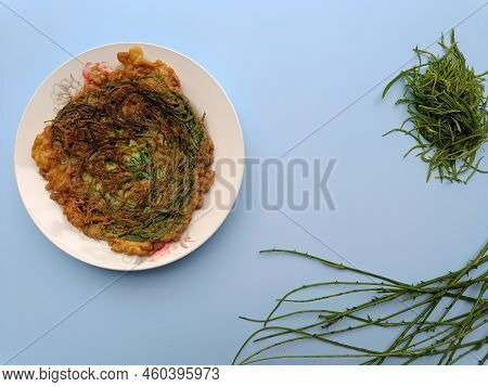 Thai Call Kai Jeow Cha Om Or Omelette With Acacia Leaves On Blue Background With Copy Space