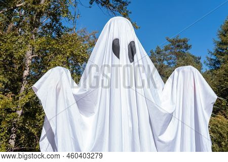 Funny Halloween. A Ittle Kid In A White Suit Holding Baskets In The Shape Of A Pumpkin, A Scary Hall
