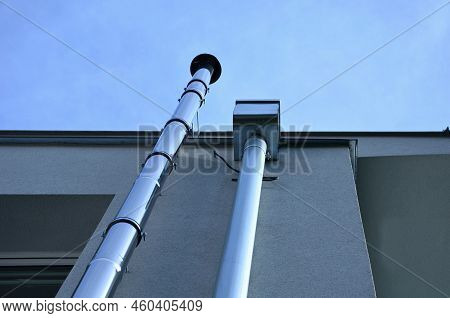 Industrial White Building With Sheet Metal Facade Of Repeating Rectangle Paneling. On Wall Are Two S