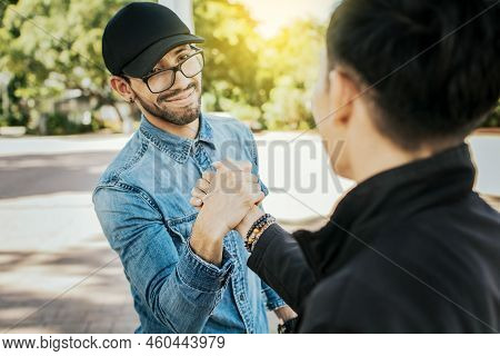 Concept Of Two Friends Greeting Each Other And Shaking Hands On The Street. Two Teenage Friends Shak