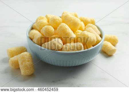 Bowl Of Delicious Crispy Corn Sticks On White Marble Table
