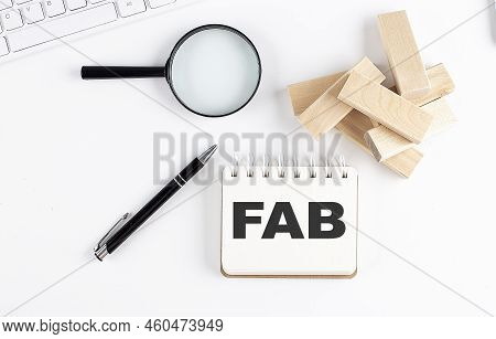 Fab - Feature Advantage Benefits Word Written On A Notebook With Block Magnifier And Pen , Business 