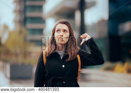 Unhappy Girl Holding A Thumbs Down Feeling Disappointed