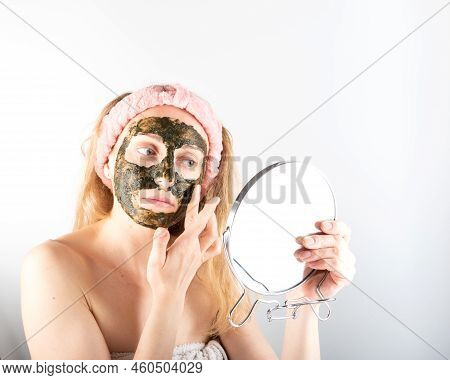 Girl Apply A Mask On Her Face. A Woman With A Mask On Her Face. Applying Herbal Face Mask. Girl With