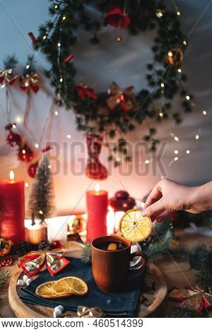 Mulled Red Wine Gluhwine In Cup With Orange, Christmas Decor Table With Candles