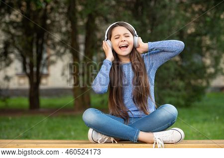 Singing Song. Teen Girl Singing Song Listening To Music In Headphones Outdoors, Singing