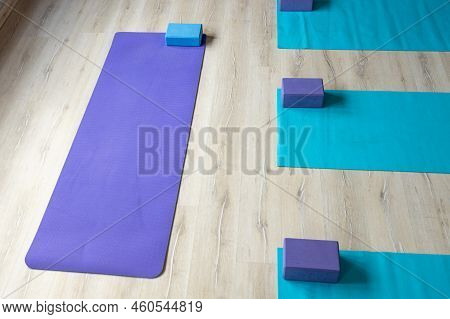 High Angle View Of Exercise Mats With Blocks Placed On Hardwood Floor In Yoga Studio