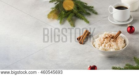 Scandinavian Rice Porridge With Cinnamon In A Bowl Surrounded By Christmas Balls. Breakfast On Chris