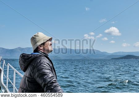 Mature Asian Man As Tourist On Boat Trip. Chivyrkuisky Bay Of Lake Baikal. Zabaikalsky National Park